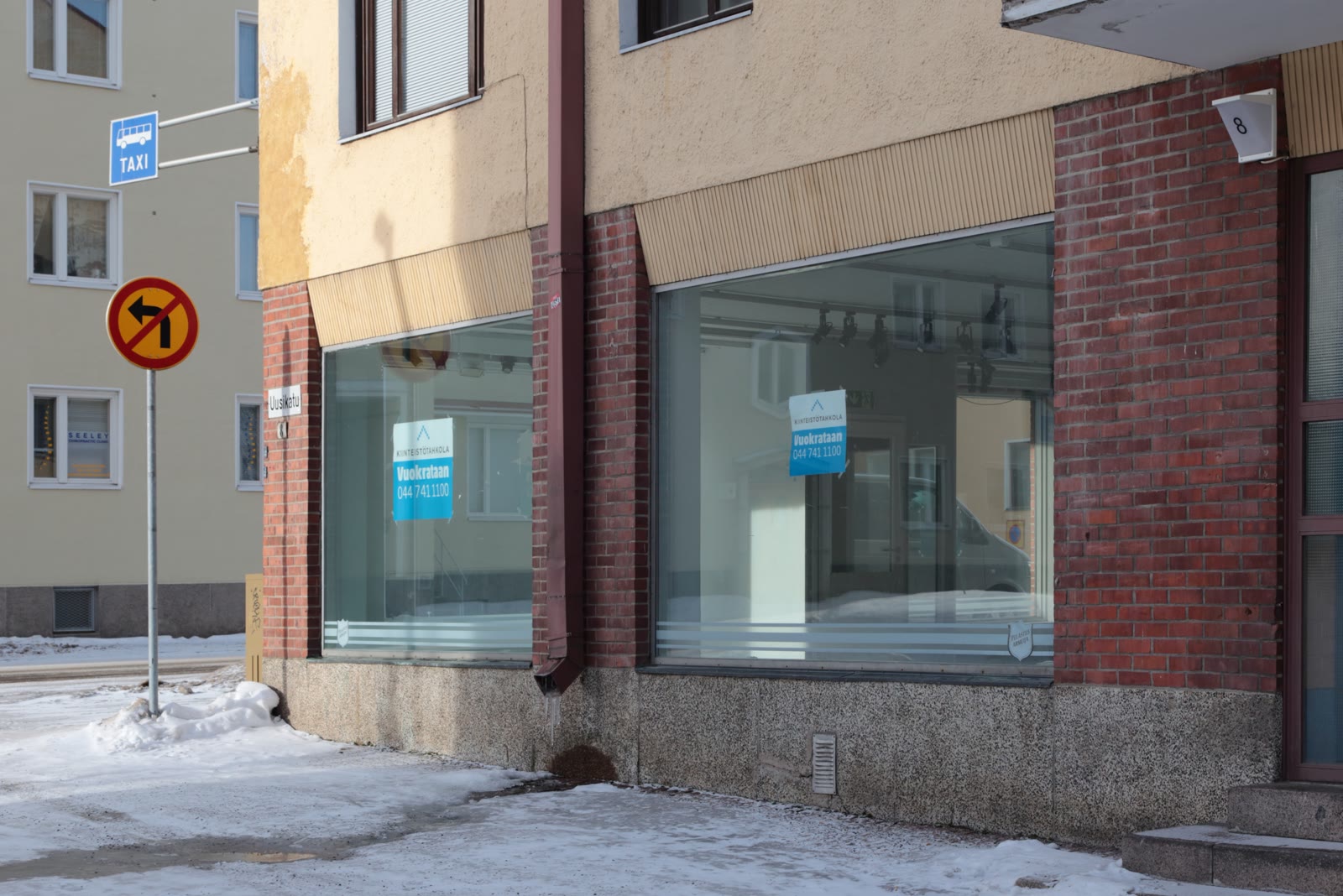 A vacant commercial unit with boarded window openings